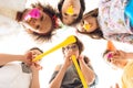 Bottom view. Joyful children are blowing on festive pipes at birthday party. Royalty Free Stock Photo