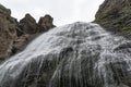 Bottom view of magnificent waterfall in high mountains.