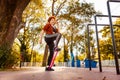 Bottom view mid adult Caucasian woman with stretching legs with elastic band in sports park. Concept of healthy Royalty Free Stock Photo