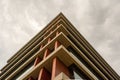 Bottom view of modern building in business district against overcast sky