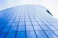 Bottom view of a modern skyscraper with glass window against blue sky. Royalty Free Stock Photo