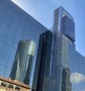 Bottom view of modern skyscrapers reflections in business district against blue sky. Business buildings in downtown. Royalty Free Stock Photo