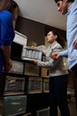 Bottom view of saleswoman demonstrating mockups of orthopedic mattresses for a sleeping bed to a couple of customers in an