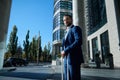 Bottom view of a self-confident successful businessman developer entrepreneur in business suit and luggage smiles looking aside Royalty Free Stock Photo