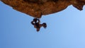 Bottom view of a stone man hanging from the rock above a shallow cave. The lone men are a mystery found in the northern Kaokoveld Royalty Free Stock Photo