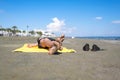 Bottom view on the teen boy feet in the sand lying on yellow towel and sunbathes on the beach. Royalty Free Stock Photo