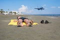 Bottom view on the teen boy feet in the sand lying on yellow towel and sunbathes on the beach. Royalty Free Stock Photo