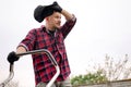 Bottom view of tired man makes a short break while cutting grass with a lawn mower after at backyard of his house Royalty Free Stock Photo