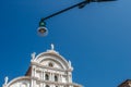 Bottom view of Traditional street lamp and an famous old Venetian church building in the middle of the day with a blue