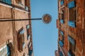 Bottom view of Traditional street lamp at an old Venetian house with wooden pins on the wire in the middle of the day