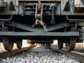 Bottom view of a train carriages forming a leak from the axles and wheels on the tracks to the bottom Royalty Free Stock Photo