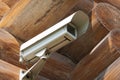 Bottom view of video camera screwed to the corner of the log house Royalty Free Stock Photo