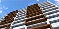 Bottom view of a white building with balconies finished with a facade board in a house built according to the most modern