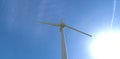 Bottom view of a white fan of an industrial wind turbine against the backdrop of the sun and deep sky. 3d render