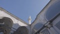 Bottom view of a white temple details with arches and long spire. Action. Beautiful historic building on blue sky Royalty Free Stock Photo