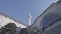 Bottom view of a white temple details with arches and long spire. Action. Beautiful historic building on blue sky Royalty Free Stock Photo