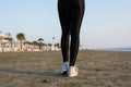 Bottom view of woman legs in the sport leggings and sneakers on the beach at the morning Royalty Free Stock Photo