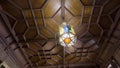 Bottom view of a wooden beautiful old fashioned ceiling with a hanging chandelier made of stained glass. Action. Details Royalty Free Stock Photo