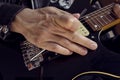 Bottom view of a young male using a leather jacket playing a black and yellow electric guitar at indoor. Royalty Free Stock Photo