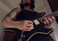 Bottom view of a young man playing a black and yellow electric guitar at indoor Royalty Free Stock Photo