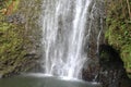 The bottom of Wailua Falls plummeting down a rocky cliff surrounded by lush vegetation in Hana, Maui Royalty Free Stock Photo