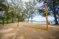 Bottom of yellow voleyball net on beach among palm trees