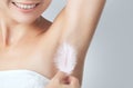 After the botulinum toxin injection procedure. A woman holds a feather in the skin in the armpits, showing dryness and lack of