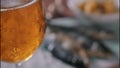 Boubles in glass of beer in front of dried fish