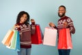 Bought a lot of purchases, seasonal sale concept. Happy african american spouses holding many colored shopping bags Royalty Free Stock Photo