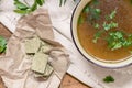 Bouillon cubes next to a bowl of broth Royalty Free Stock Photo