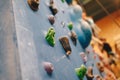 Bouldering wall knobs. Young boys practice climbing skills in blurred background Royalty Free Stock Photo