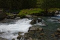 A river`s water turns white as it flows over boulders Royalty Free Stock Photo
