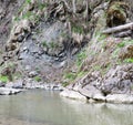 Boulders and cliff of mountain stream shore