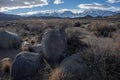 Boulders in desert valley with snowy mountain range in distance Royalty Free Stock Photo