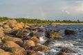 Boulders, forest, shore, evening light, sunset, clouds, blue sky and rainbow on the Baltic Sea Royalty Free Stock Photo