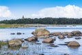 Boulders, forest, shore, evening light, sunset, clouds, blue sky and rainbow on the Baltic Sea. Royalty Free Stock Photo