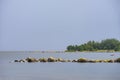 Boulders, forest, shore, evening light, sunset, clouds, blue sky and rainbow on the Baltic Sea. Royalty Free Stock Photo