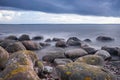 Boulders, forest, shore, evening light, sunset, clouds, blue sky and rainbow on the Baltic Sea. Royalty Free Stock Photo