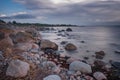 Boulders, forest, shore, evening light, sunset, clouds, blue sky and rainbow on the Baltic Sea. Royalty Free Stock Photo