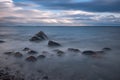 Boulders, forest, shore, evening light, sunset, clouds, blue sky and rainbow on the Baltic Sea. Royalty Free Stock Photo