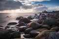 Boulders, forest, shore, evening light, sunset, clouds, blue sky and rainbow on the Baltic Sea. Royalty Free Stock Photo