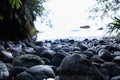 Boulders at waters sedge in small shady bay