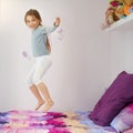 Bouncing for joy. Portrait of a cute little girl jumping on her bed at home. Royalty Free Stock Photo