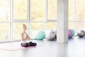 Bound Angle, lotus posture. Woman doing yoga, looking at camera.