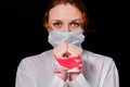 Bound hands of a woman in a medical mask. Portrait of a girl on a black background, concept of problems with the coronavirus