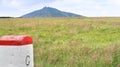 Boundary stone in Krkonose, Giant Mountains, with mark C like Czechia, with the highest mountain of Czechia, Snezka in distance Royalty Free Stock Photo