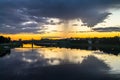 Mesmerizing blazing sunset over the mirror glossy surface of the Volga river, reflecting dramatic sky. City of Tver, Russia.