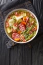 Bouneschlupp is a traditional Luxemburgish green bean soup with potatoes  bacon  and onions close-up in a plate. Vertical top view Royalty Free Stock Photo