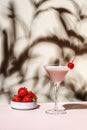 Bounty martini summer cocktail drink with vodka, liqueur, cream, strawberries and ice in glass with red cocktail cherry. Beige Royalty Free Stock Photo