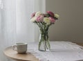 A bouquet of asters in a glass vase, a cup of coffee on a round table Royalty Free Stock Photo